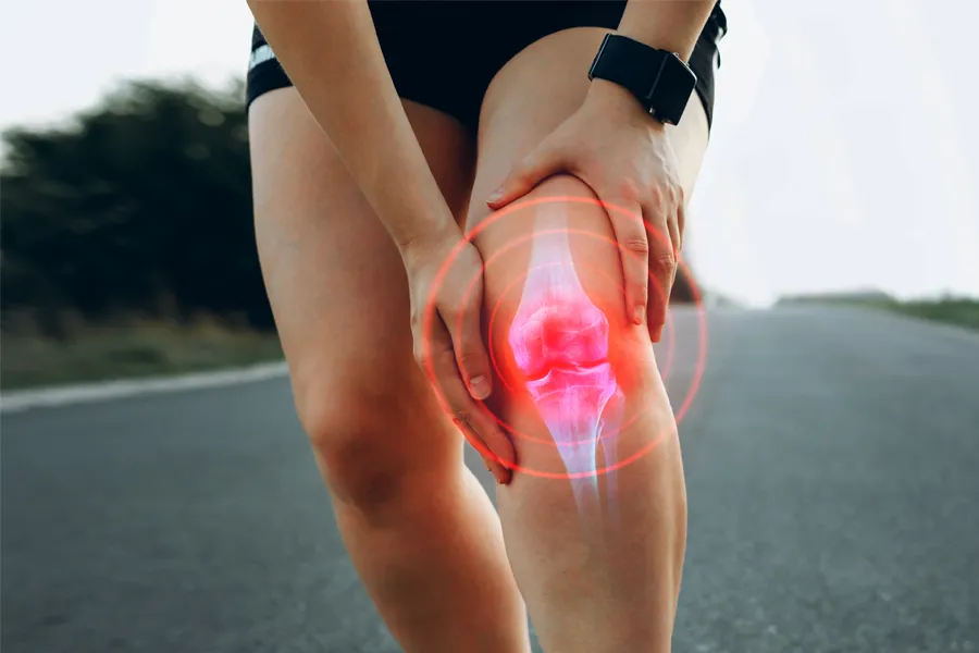 ACL-Tears-Clinic A woman running on the road holds her knee in pain. Schedule treatment for ACL tears from Dr. Noelani Rodriguez in San Diego.