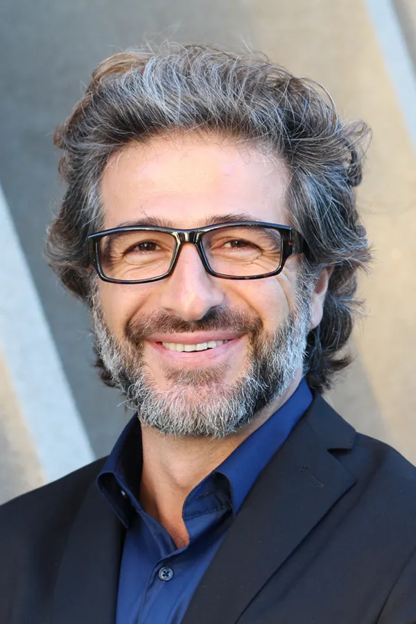 Andropause-and-Low-Testosterone-Treatment A man with glasses, salt and pepper hair and a beard smiling because he received treatment for andropause and low testosterone from Dr. Noelani Rodriguez in San Diego.