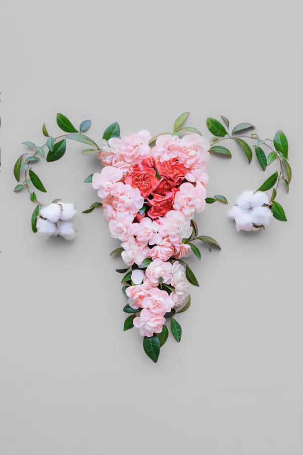 Endometriosis-Treatment Flowers on a gray background, arranged in the shape of the female reproductive system, representing Endometriosis treatment from Dr. Noelani Rodriguez in San Diego.