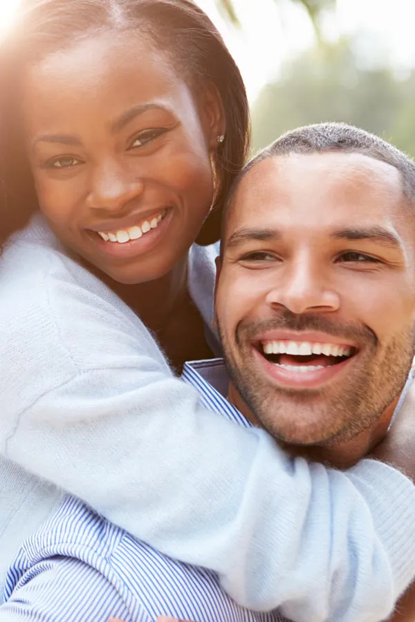 Erectile-Dysfunction-Treatment A woman riding on a man's back, both smiling due to help with erectile dysfunction from Dr. Noelani Rodriguez in San Diego.