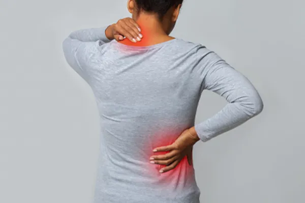 Fibromyalgia-Clinic An image from behind of a woman suffering from Fibromyalgia holding her hands on her neck and lower back. Get fibromyalgia care from Dr. Noelani Rodriguez in San Diego.