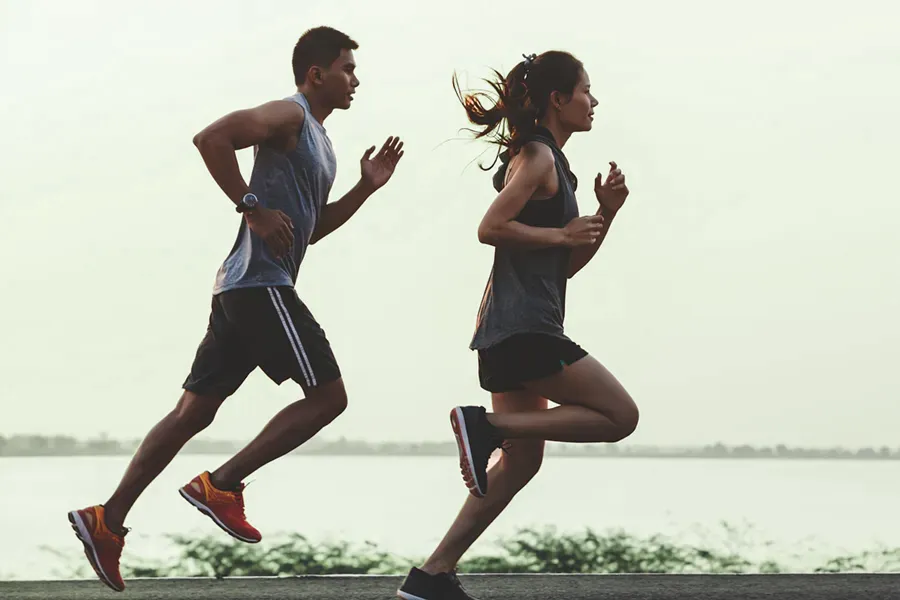 GLP-1-Weight-Loss-Injections-Clinic Man and woman running near a waterfront, reflecting the physical transformation possible with GLP-1 weight loss injections offered by Dr. Noelani Rodriguez in San Diego.
