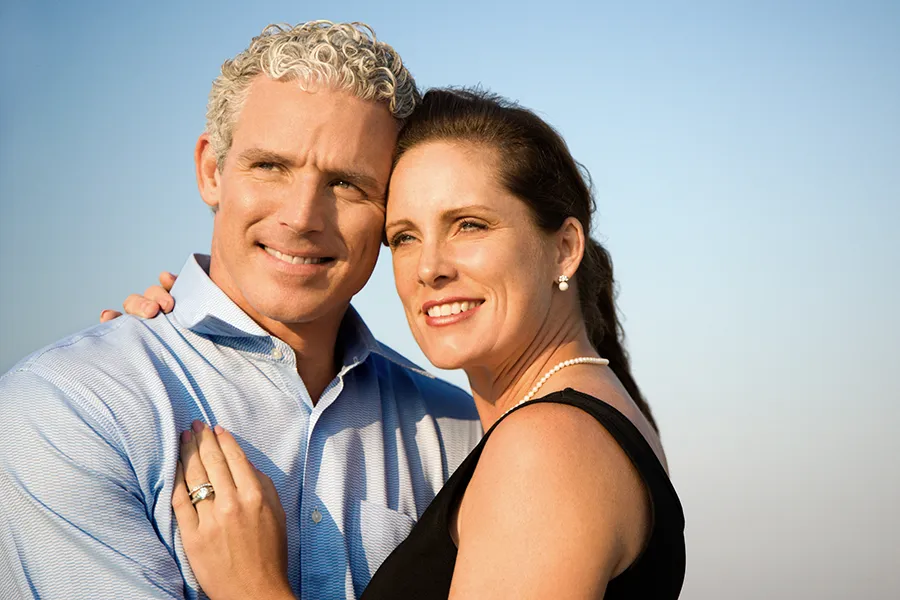 Healthy-Aging-Peptides-Doctor A middle-aged caucasian couple embraces in the sunshine, happy with the healthy aging peptide treatments from Dr. Noelani Rodriguez in San Diego