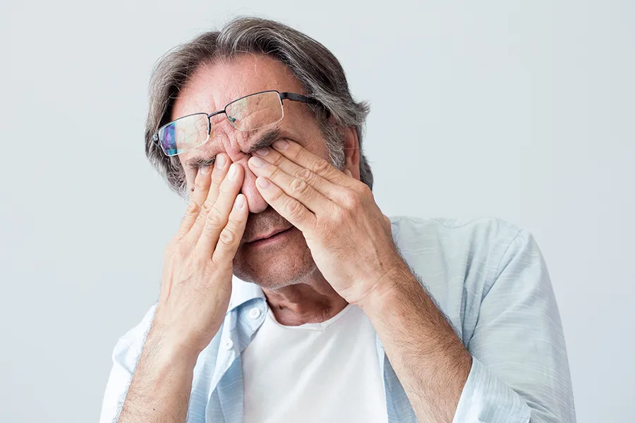 Migraine-Clinic Get migraine relief with Dr. Noelani Rodriguez's functional medicine for migraines treatment in San Diego, represented by an older man rubbing his eyes due to head pain.