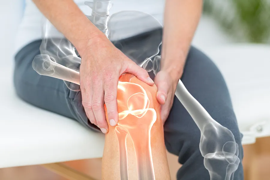 Osteoarthritis-Clinic A 3D illustration of the skeleton over the body of a woman who holds her knee in pain, where the area is highlighted. Schedule osteoarthritis treatment from Dr. Noelani Rodriguez in San Diego.