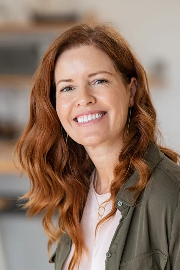 Peptides-for-Hair-Restoration-Treatment A woman with beautiful long red hair smiles due to the success of peptides for hair restoration treatments from Dr. Noelani Rodriguez in San Diego.