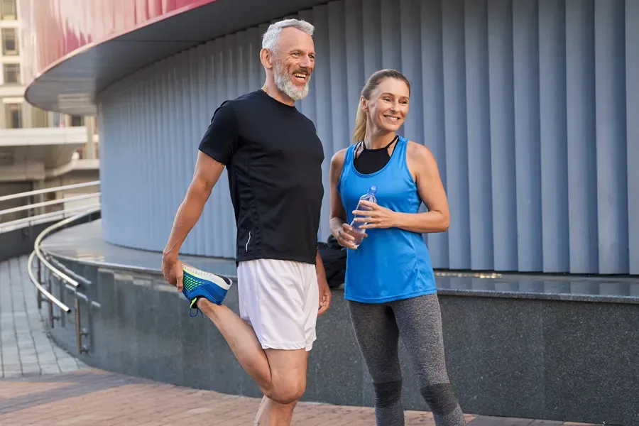 Peptides-for-Healing-and-Recovery-Doctor A middle-aged couple happily stretch and prepare for exercise after receiving effective peptide therapy for healing and recovery from Dr. Noelani Rodriguez in San Diego.