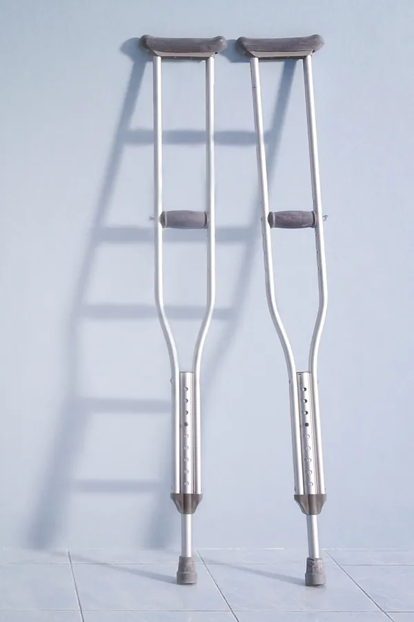 Peptides-for-Healing-and-Recovery-Treatment A pair of crutches rest against a gray wall, representing peptide therapy for healing and recovery from Dr. Noelani Rodriguez in San Diego.