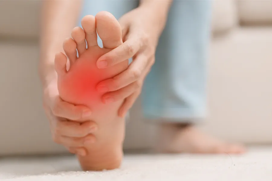 Plantar-Fasciitis-Clinic A woman holds her foot in pain. Schedule plantar fasciitis treatment from Dr. Noelani Rodriguez in San Diego.