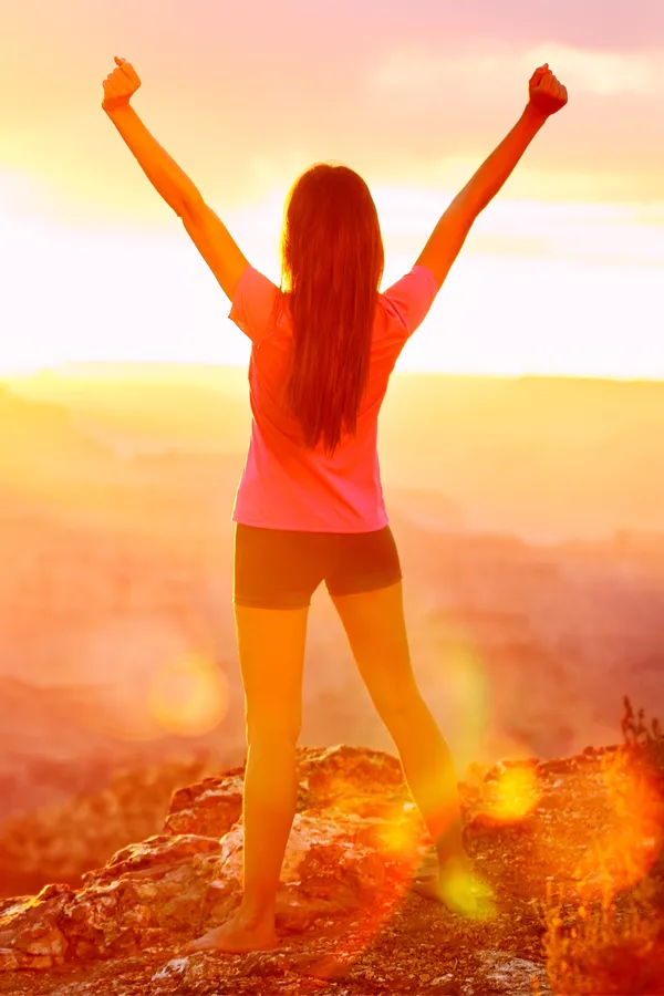 Rotator-Cuff-Treatment A woman raises her arms on a hilltop. Get rotator cuff treatment from Dr. Noelani Rodriguez in San Diego.