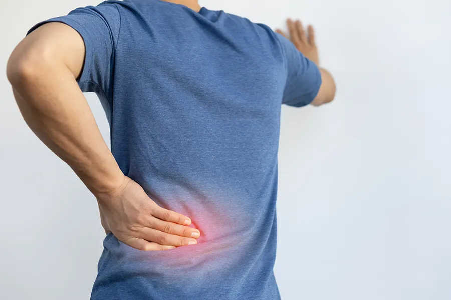 Sciatica-Clinic A man holds his lower back in pain. Schedule sciatica treatment from Dr. Noelani Rodriguez in San Diego.
