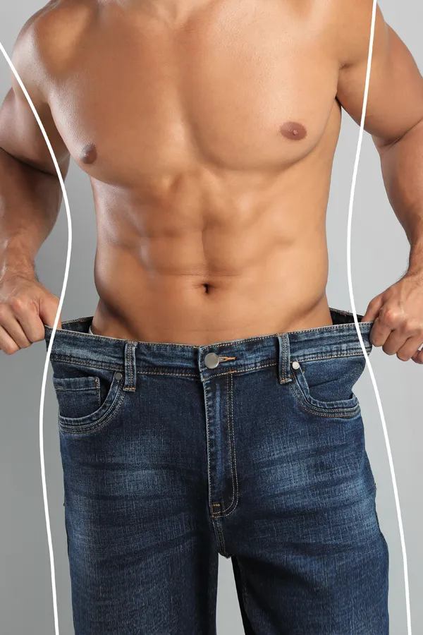 Semaglutide-Weight-Loss-Treatment A strong shirtless man in jeans holds the waistlines of his too-big jeans to show the success of semaglutide weight loss from Dr. Noelani Rodriguez in San Diego.