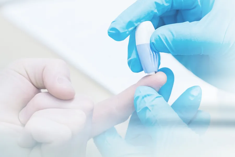 Type-2-Diabetes-Clinic Gloved hand performing a blood sugar check with a lancet. Dr. Noelani Rodriguez offers expert Functional Medicine for Type 2 Diabetes care in San Diego.