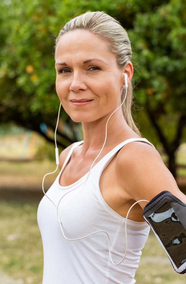 fibromyalgia-doctor Middle-aged, active woman taking a break to smile at the camera during a run, representing successful Bioidentical Hormones for Fibromyalgia Relief offered by Dr. Noelani Rodriguez in San Diego.